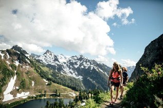 Hikers on a rocky stretch of trail on a sunny day.