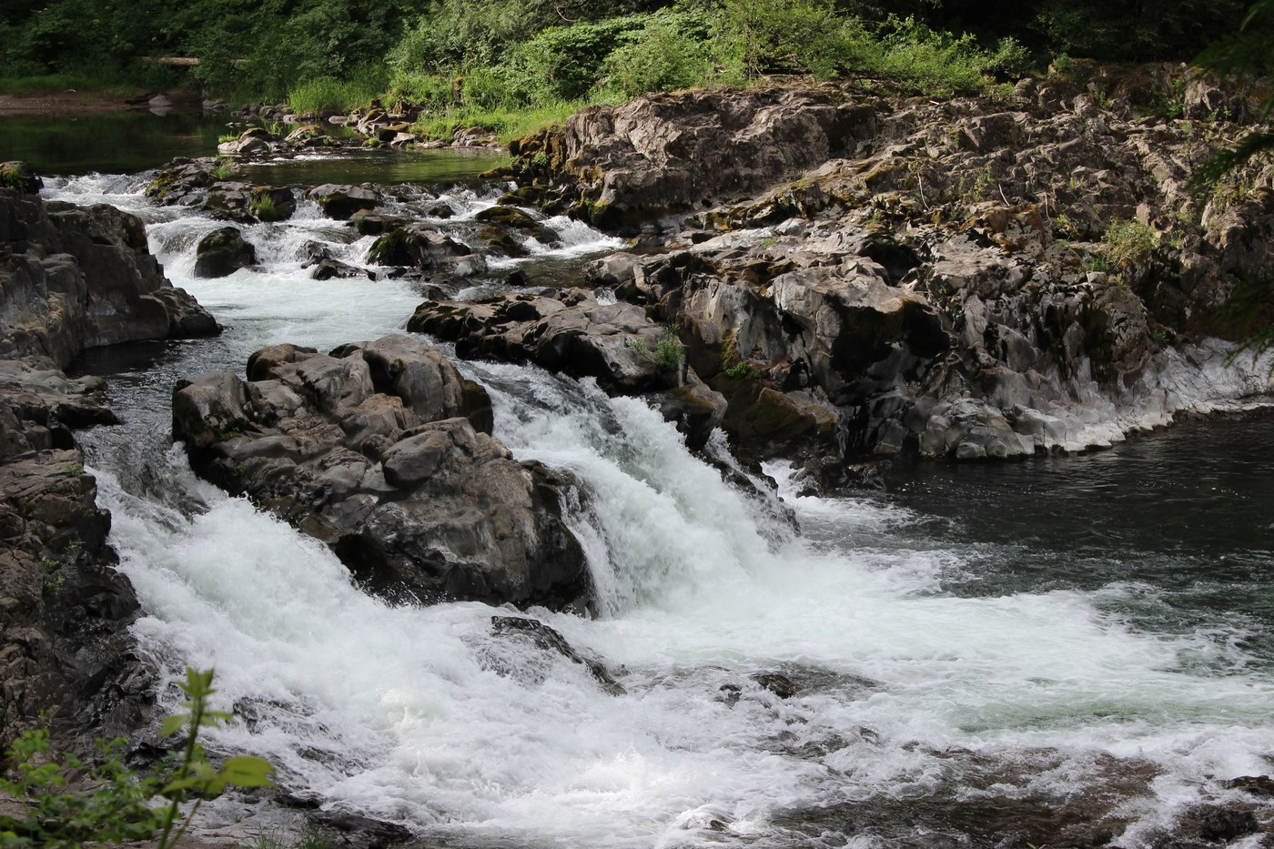 A wide short waterfall flowing over rocks. Photo by Tyaira36. 