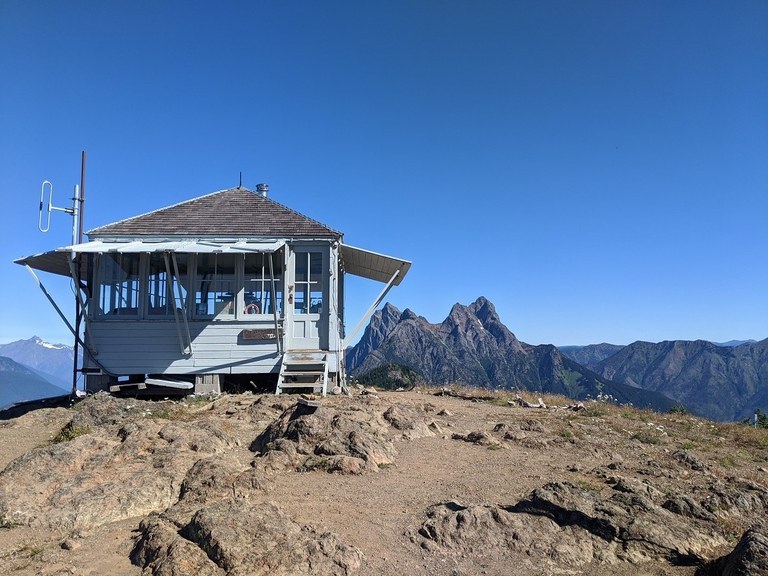 The signature lookout. Photo from WTA archives  A fire lookout on a barren mountain top.