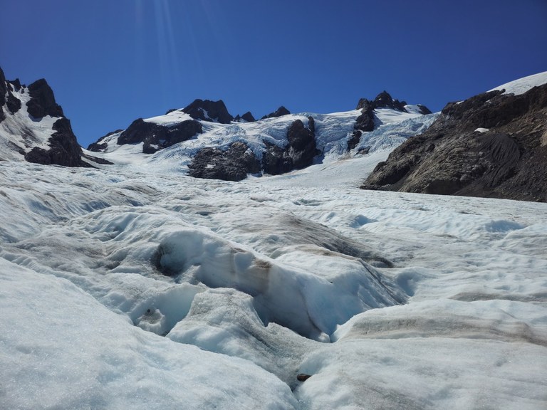 A snowy glacier with rocks.