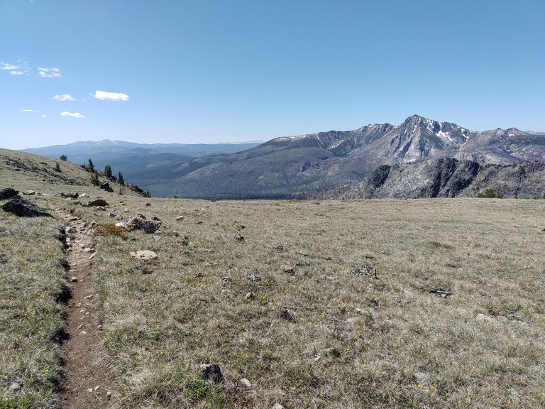 A trail leads through a field with expansive views. Photo by melanib.