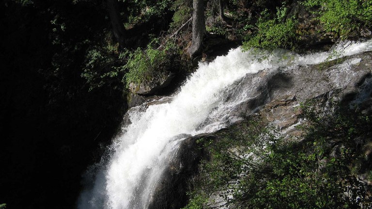 A rushing waterfall flies over the edge of a bluff on the Foggy Dew Trail. 