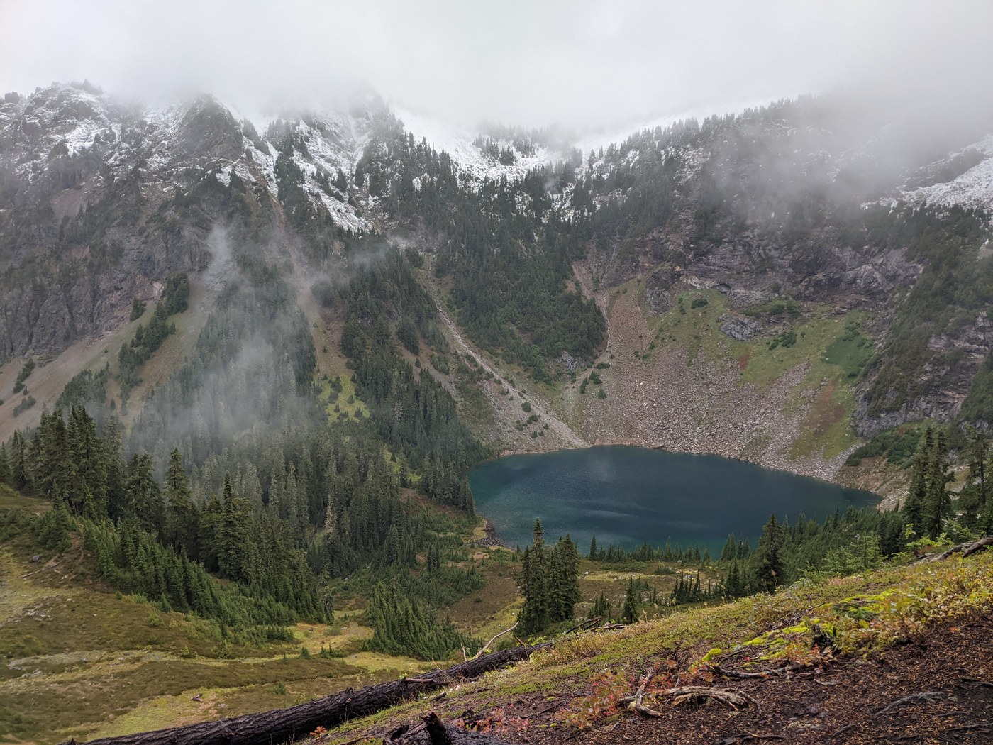 A small blue lake surrounded by steep gray mountains. 
