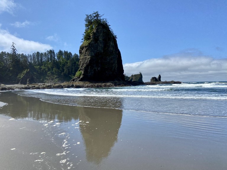 Second Beach has seastacks, tidepools, even a hole in the rock that provides an eerie whistling in heavy wind. Photo by Blue Hiker.  A seastack in the ocean at the shoreline of Second Beach