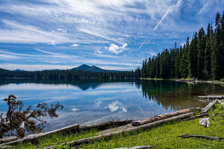 Photo of a lake with a mountain in the distance and trees to one side