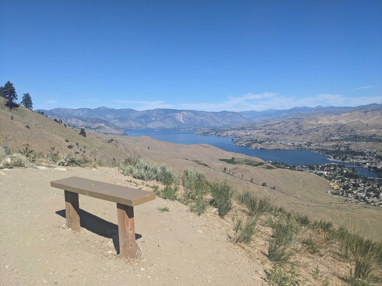 Photo of a viewpoint with bench in the foreground and a canyon and river below