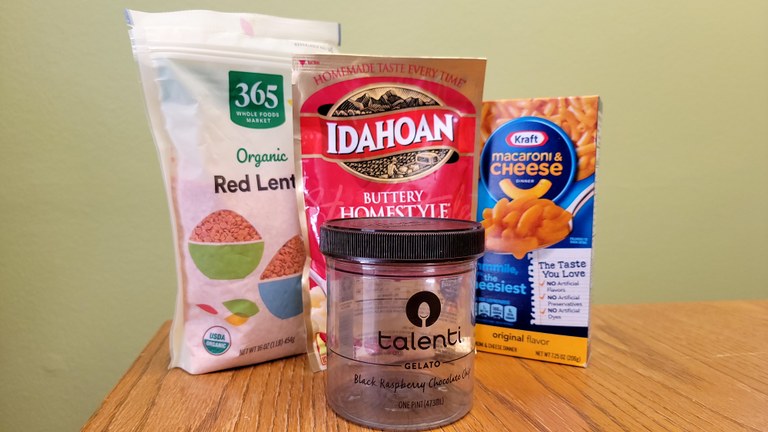A plastic jar sits on a desk with dehydrated foods.