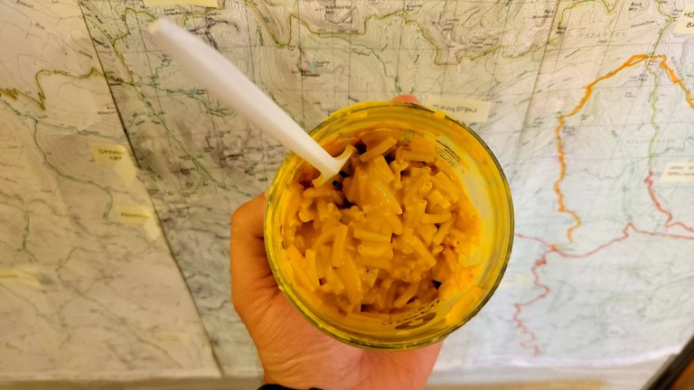 A jar of mac and cheese stairs back up at the camera.