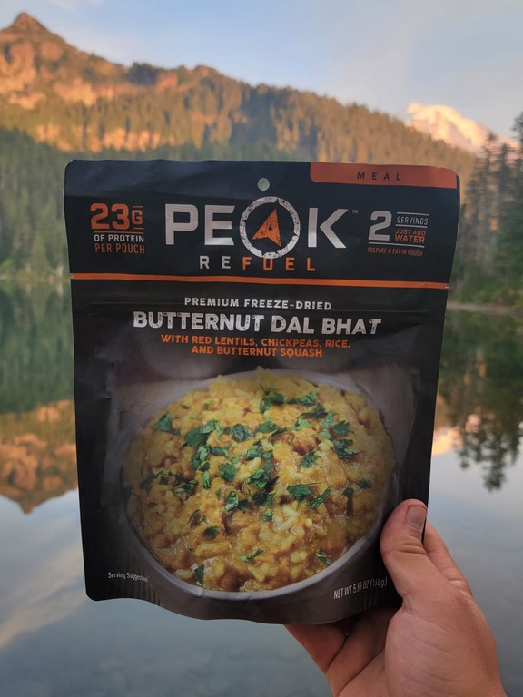 A commercial dehydrated meal is showcased at an alpine lake.