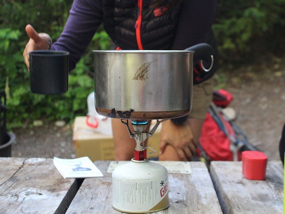 A fuel canister being used to boil water at camp.