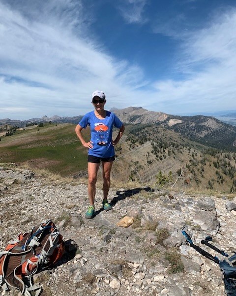 Image: A picture of Karen Daubert posing on trail with her 2021 Hike-a-Thon shirt. Photo by Karen Daubert.