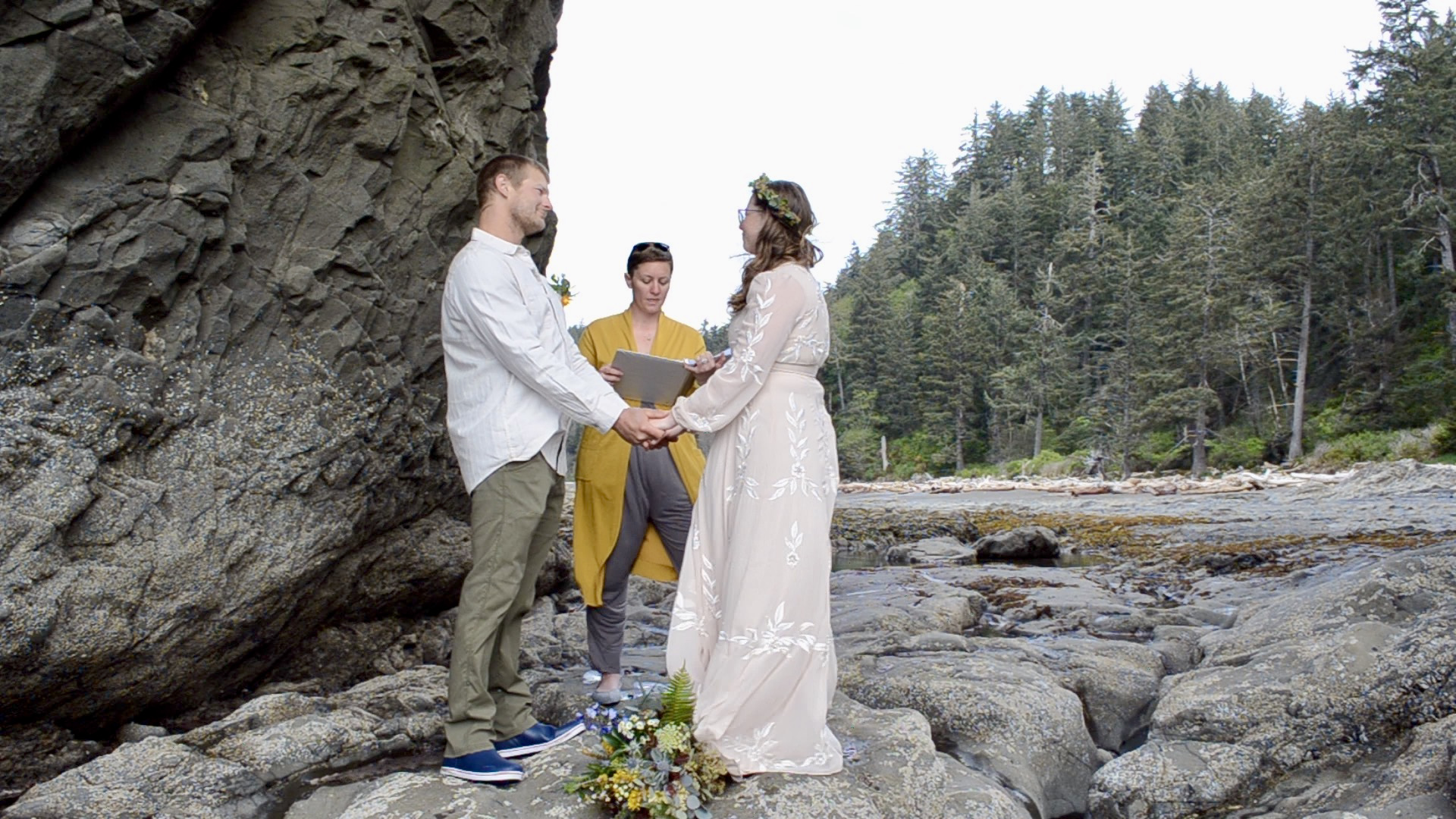 A wedding ceremony on the beach. Photo by Peter Mason. A couple getting married by an officiant on the beach. Photo by Peter Mason.