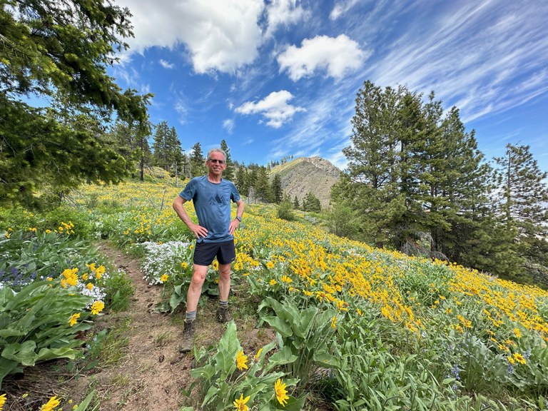 Wide-angle photos work well to showcase images with a strong focal point or when you want the subject and the background to both be in clear focus. Photo by Doug Diekema A hiker stands among a field of flowers.