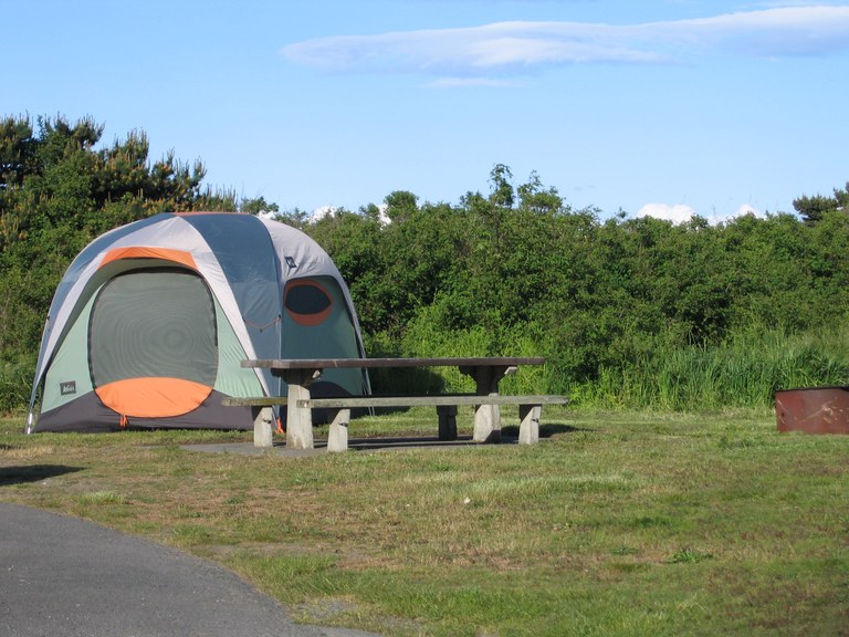 Fort Worden A tent set up next to picnic table at a grassy campsite.