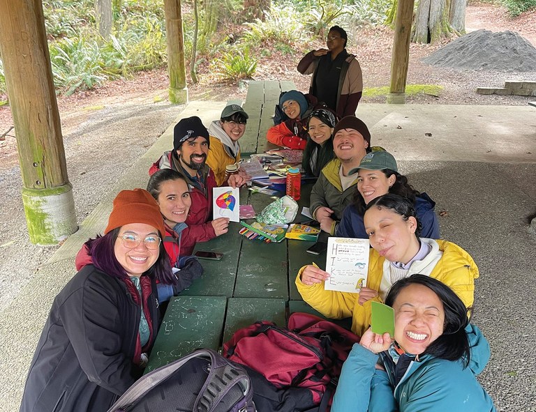 The ELP cohort and partners share in conversation on picnic benches.