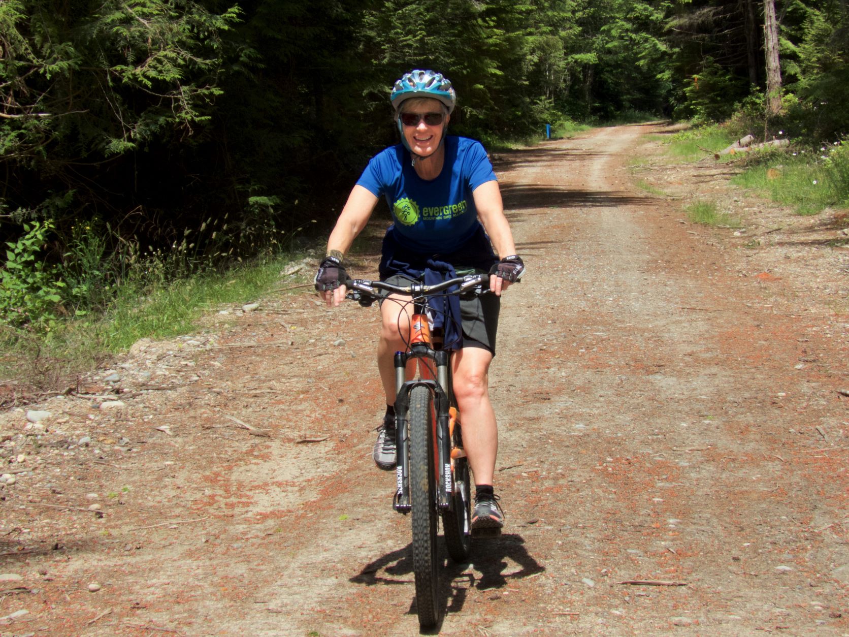 Lynn on a bike Lynn riding a bike on a wide dirt path in Port Gamble.