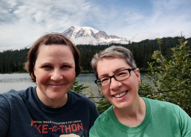 Two hikes smile in front of a lake. 