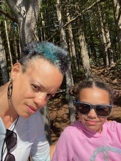 Photo of KJ Williams courtesy of KJ Williams Two people smile taking a selfie in the woods.