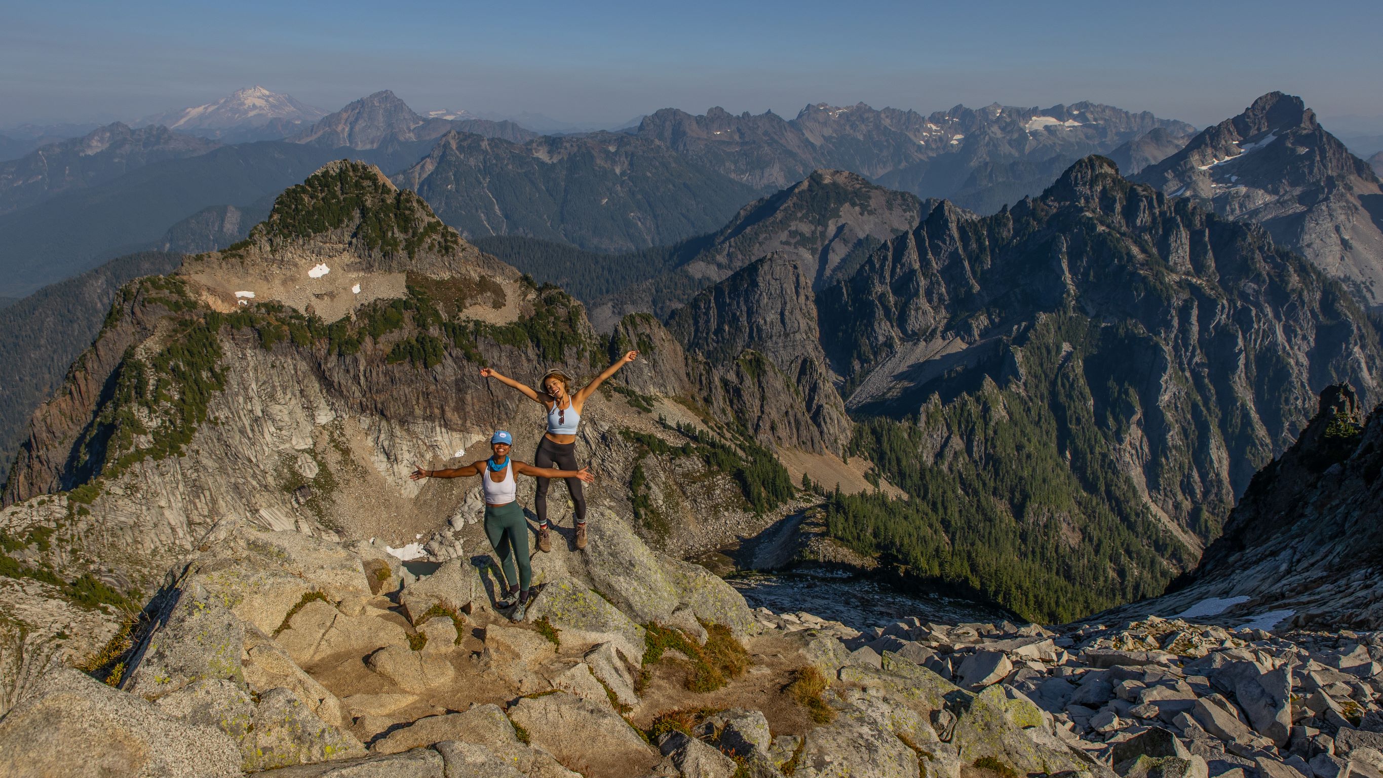 Chelsea Murphy and Michelle Nitardy stand atop a rocky peak. Chelsea Murphy and Michelle Nitardy stand atop a rocky peak.