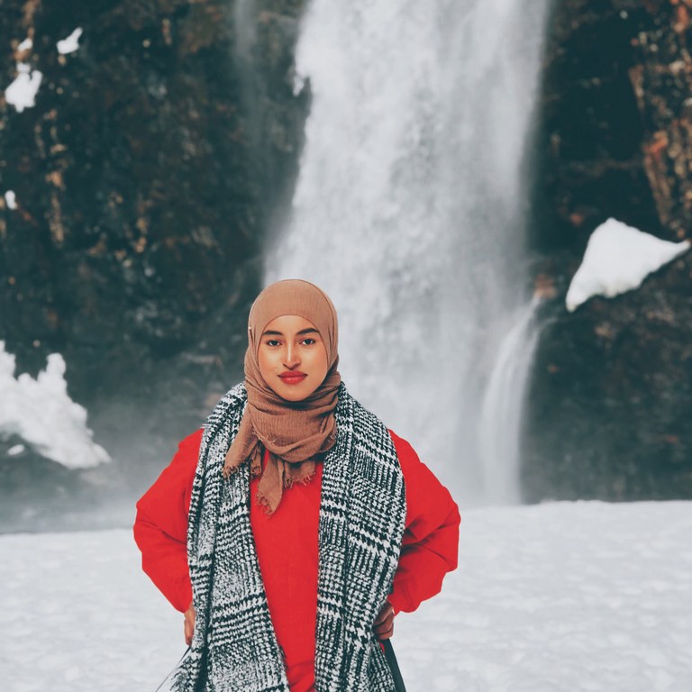 Hamziye in front of waterfall. Photo courtesy Hamziye Aman. Hamziye in front of waterfall. Photo courtesy Hamziye Aman.