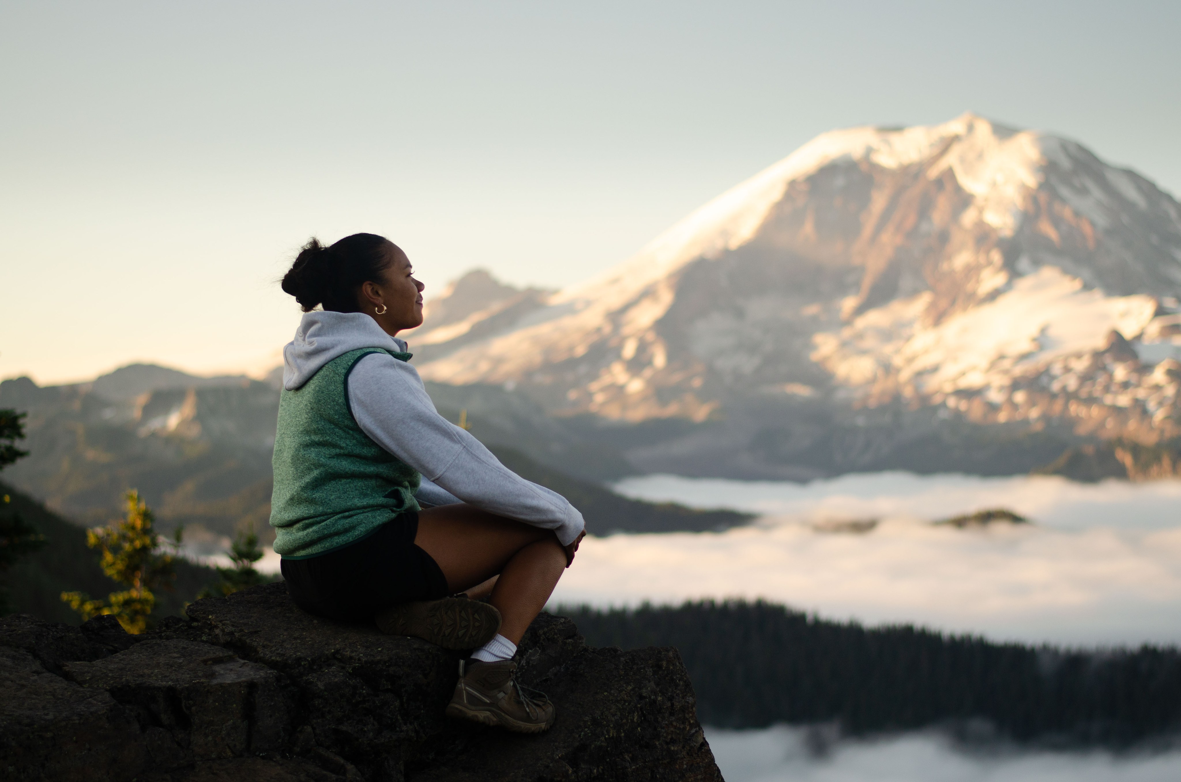 toddler on bridge in center of frame balances giant camera and lens while shooting a subject off frame to the right hand side. 