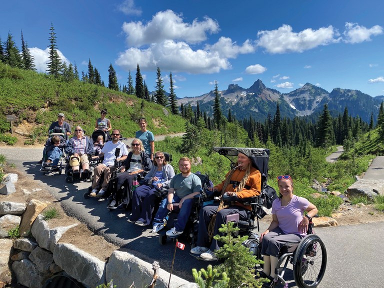 A group of hikers in wheelchairs on a paved trail at Mount Rainier.