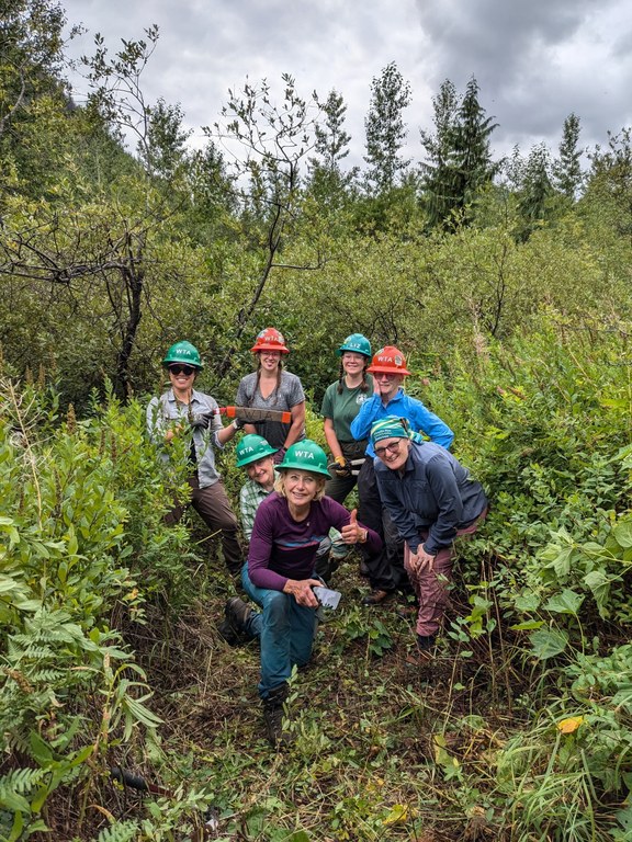 A WTA crew poses among thick brush.