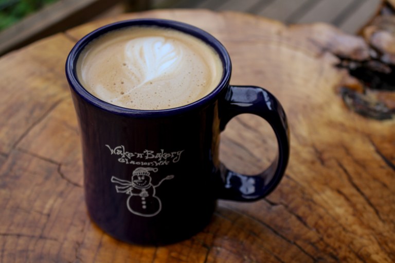 Grab a cup of hot caffeine — or a yummy treat — during your visit at the Wake 'n Bakery A Wake 'n Bakery cup with coffee in it.