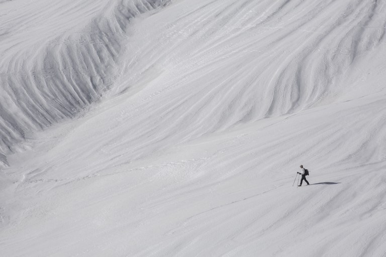 hiker in snow descending mountainside
