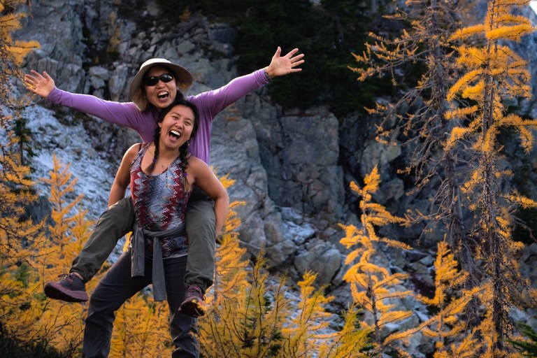 mother and daughter smiling on hiking trail