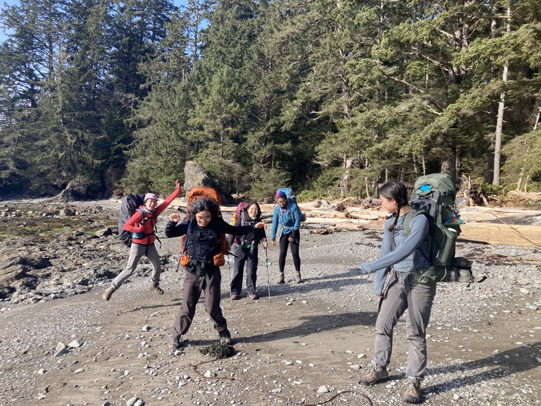 Five people from WTA's 2022 Emerging Leaders Cohort in dance poses on a backpacking trip