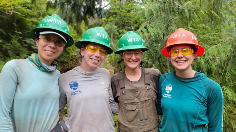 Four LTF crew members smile with hard hats on.
