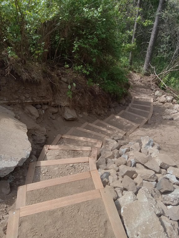 The staircase replaces an eroded gully, providing safer and more convenient access for trail users to reach the southern end of the park. Photo by Andrew Zimmerman A staircase winds between piles of rubble and vegetation.
