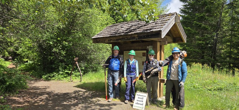 A crew of volunteer veterans at a trailhead.