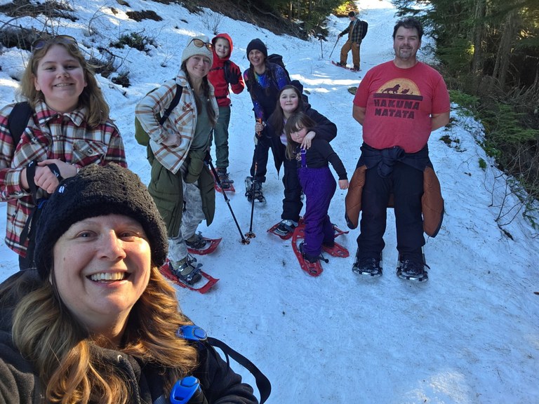 A group of snowshowers pause in the trail to take a group photo