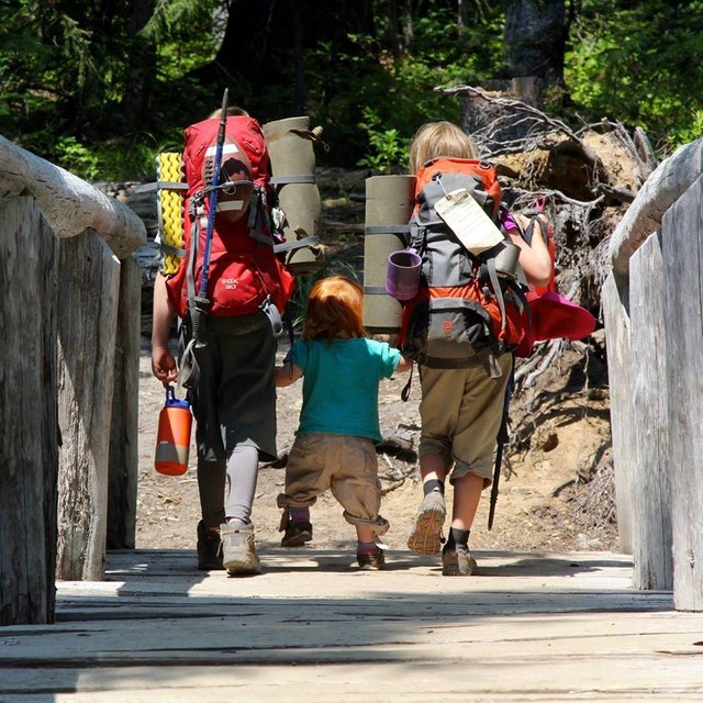 Elissa and Joey help Vivian across the bridge. Photo courtesy Lorelei Felchlin.