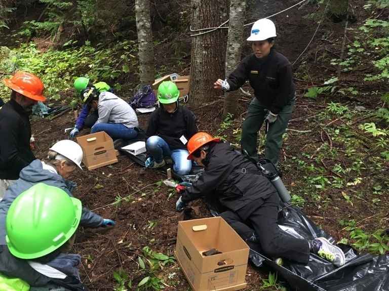 Aleta Eng, USFS partnership specialist, holds up a shard of Asian serving ware with a distinct bamboo pattern found during an archaeological exploration with the Wing Luke Museum of the Asian Pacific American Experience. Photo courtesy of Mt. Baker- Snoqualmie National Forest.
