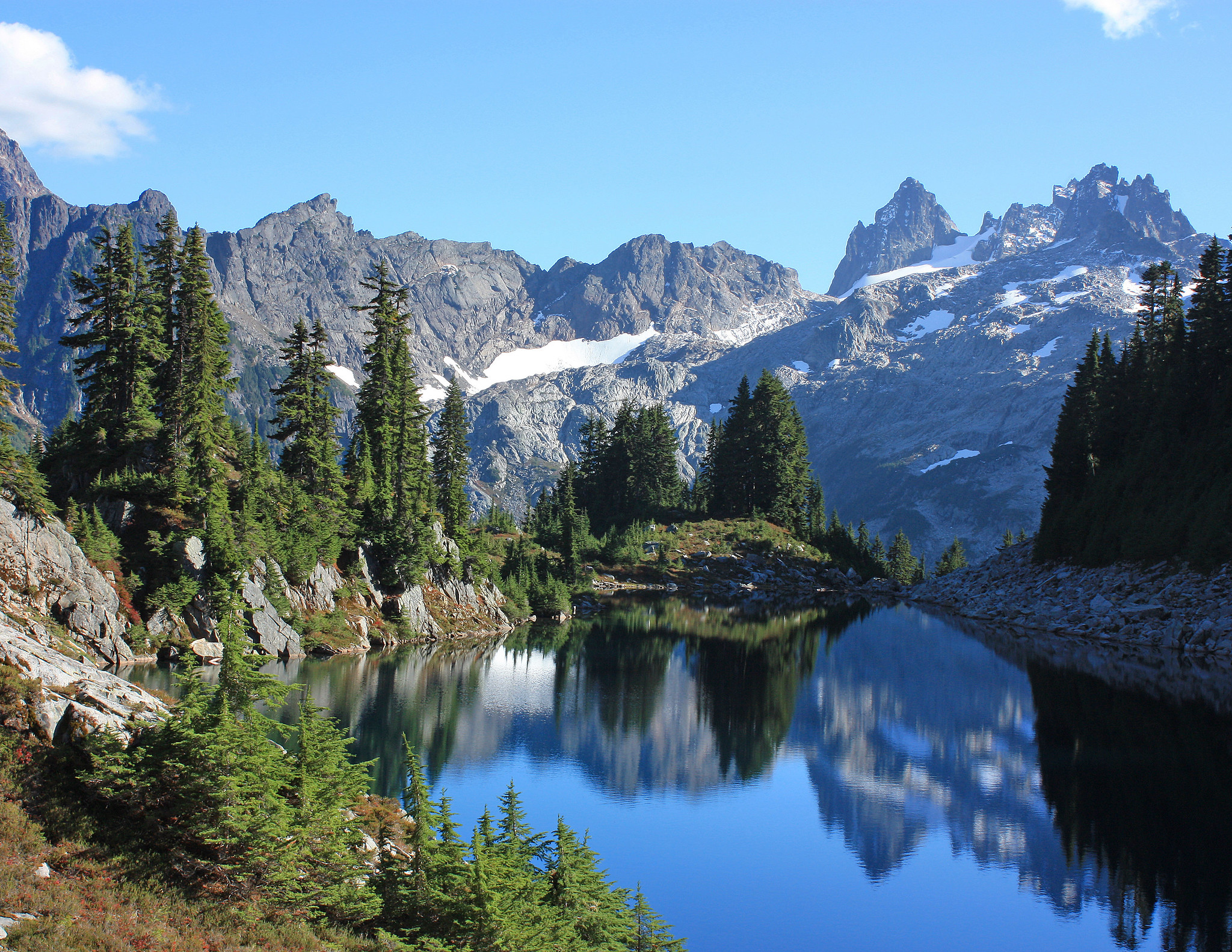 Reflections in an alpine lake with mountains in the background on the West Fork Foss River/Middle Fork Snoqualmie River Trail in the Alpine Lakes Wilderness. Photo by Gary Cummins.