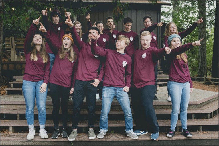 A group of teens in WTA shirts pose for a team photo.