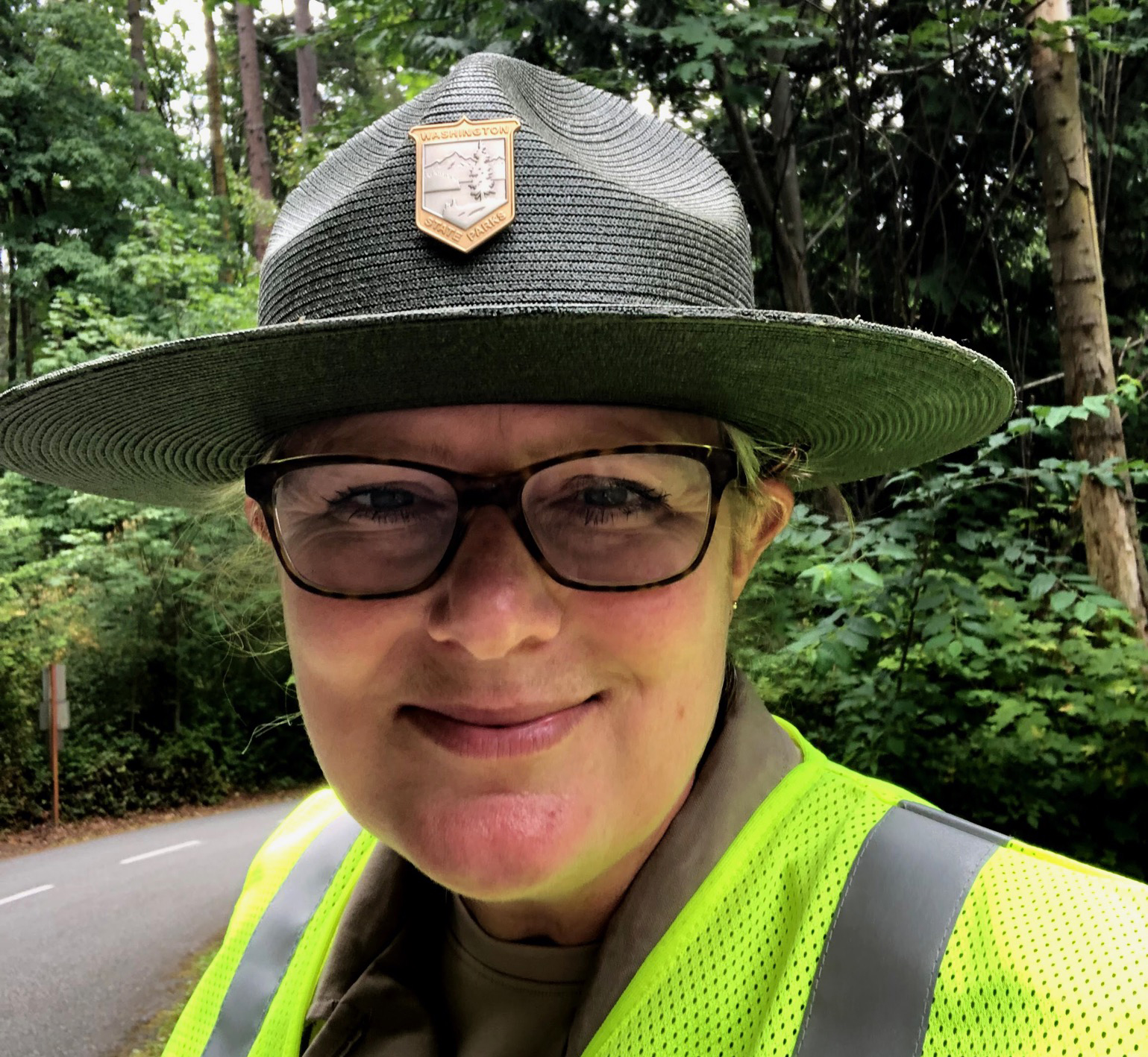 Amber Forest Amber wears her uniform, including a flat brimmed hat and colorful safety vest.