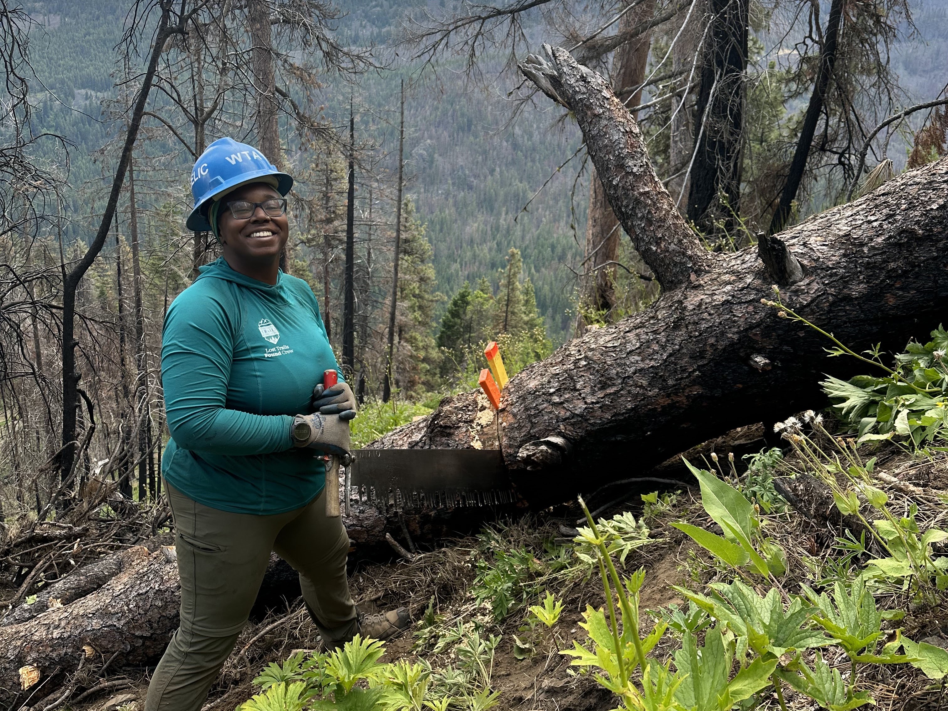 Angelic smiling at the camera using a crosscut saw on a Lost Trails Found crew. Photo courtesy of Angelic Friday.