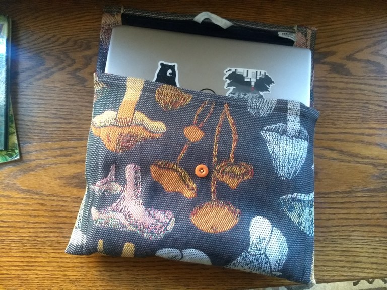 Laptop case with a fungi pattern and cute button.