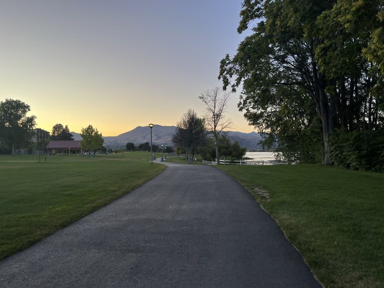 Mountains in the distance with the water to the right of the winding Apple Capital Recreation Loop Trail. Photo by hikingwithlittledogs.