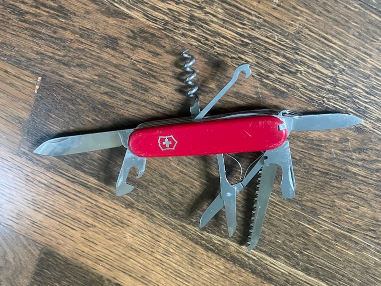 A Swiss Army Knife on wood grain.