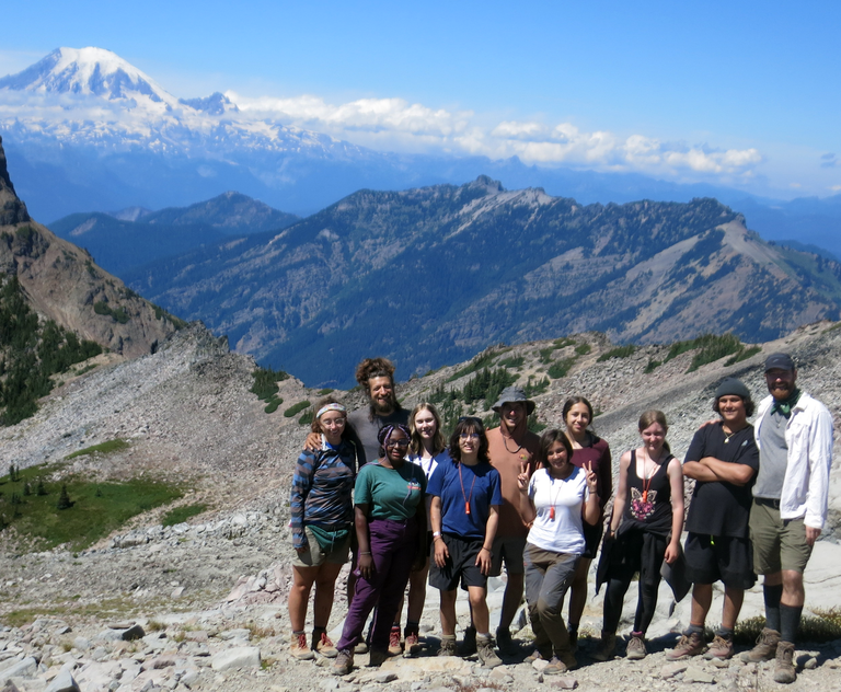 Wild Grief A group of youth and adults pose on trail in front of Mount Rainier.