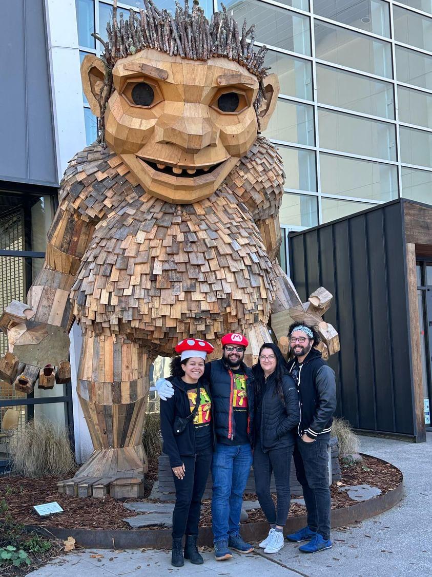 A group of urban hikers standing next to a giant wooden troll at Hiram M. Chittenden - Ballard Locks in Seattle. Photo by Joseph Gonzalez.