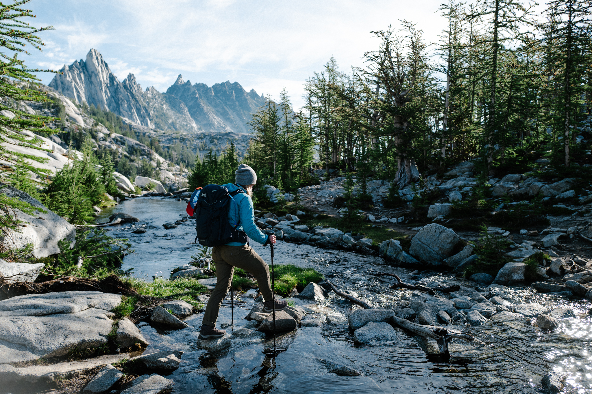 Hiker crosses a stream at Perfection Lake in the Enchantments.