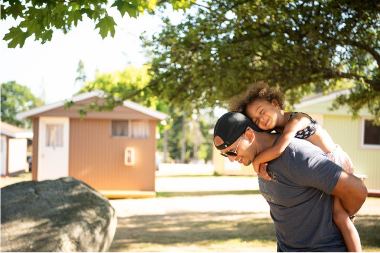 An adult carrying a child piggyback.