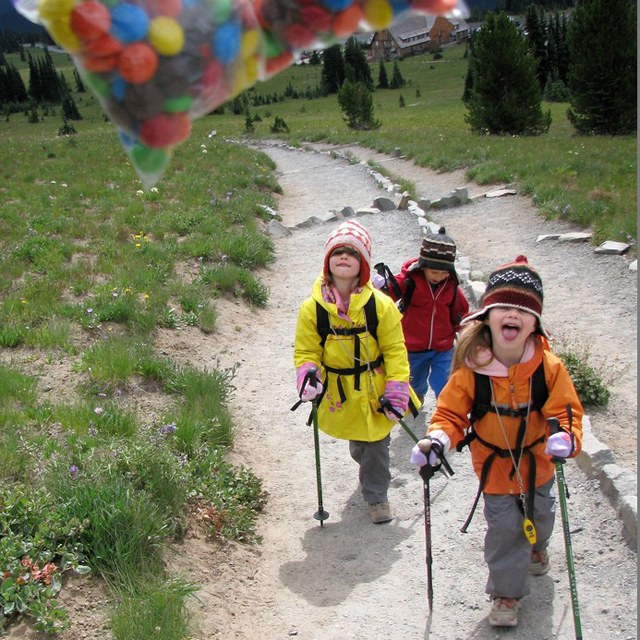 A group of kids looks at a brightly colored bag of candy. 