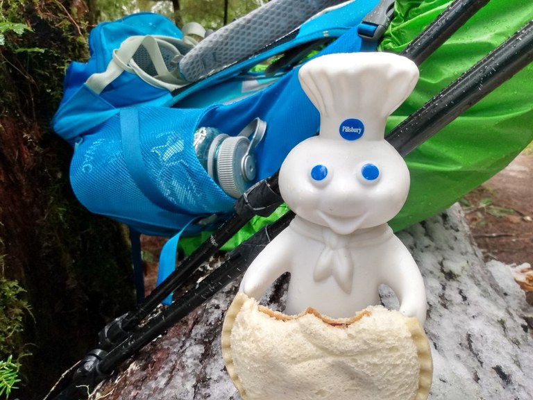 A Pillsbury Doughboy figurine poses with an Uncrustable sandwich with a backpack behind it. Photo by Catherine Vine.